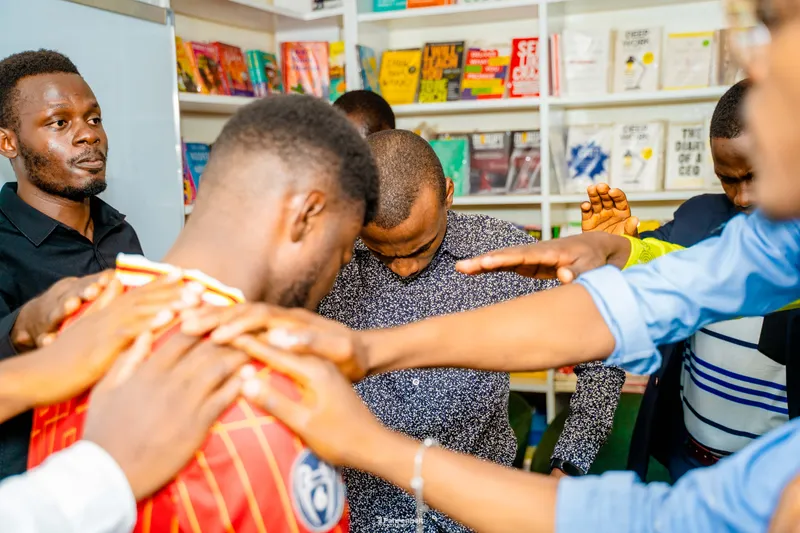 Men praying together at a Real Men gathering in Yaoundé